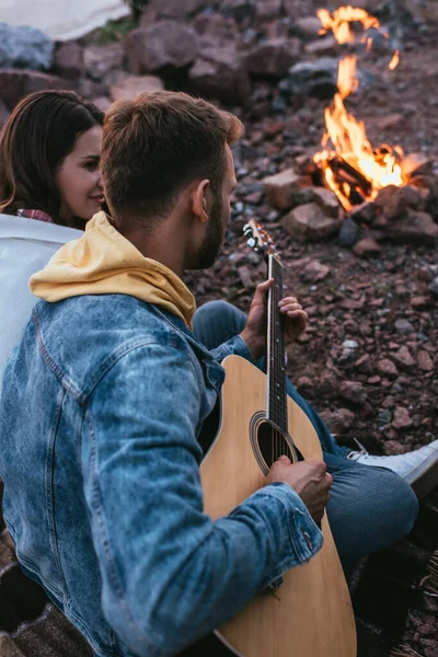 Foco Seletivo Homem Barbudo Tocando Guitarra Acústica Perto Namorada Fogueira — Fotografia de Stock