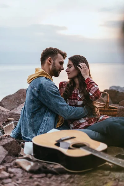 男人拥抱女友靠近音响吉他的选择性焦点 — 图库照片