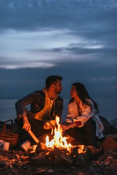 夫妻在篝火边互相凝视的选择性焦点 — 图库照片