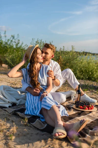 Homem Feliz Beijando Menina Chapéu Palha Sentado Perto Comida Saborosa — Fotografia de Stock