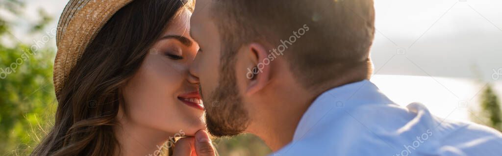 panoramic concept of bearded man kissing happy young woman 