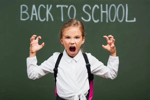 Selective Focus Angry Schoolgirl Showing Scaring Gesture Chalkboard Back School — Stock Photo, Image