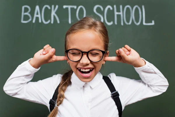 Selective Focus Displeased Schoolgirl Eyeglasses Plugging Ears Fingers Back School — Stock Photo, Image