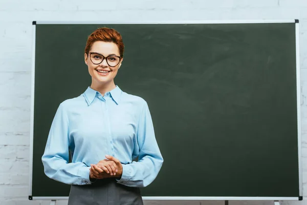 Happy Teacher Eyeglasses Looking Camera While Standing Clenched Hands Chalkboard — Stock Photo, Image