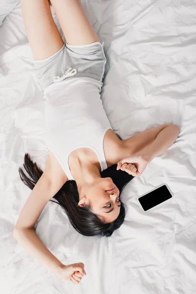 Top View Cheerful Asian Girl Stretching Looking Smartphone Bed — Stock Photo, Image