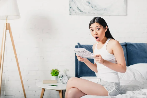 Shocked Asian Woman Looking Camera While Holding Newspaper Bed Home — Stock Photo, Image