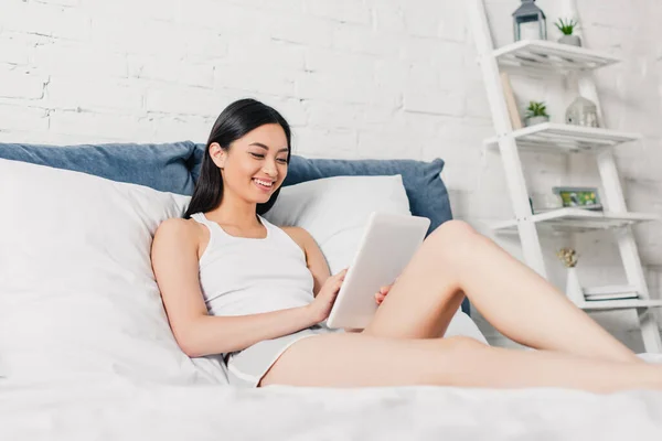 아름다운 아시아인 여성이 침대에서 디지털 태블릿을 사용하는 선택적 — 스톡 사진