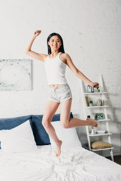 Alegre Ásia Mulher Pijama Saltando Cama — Fotografia de Stock