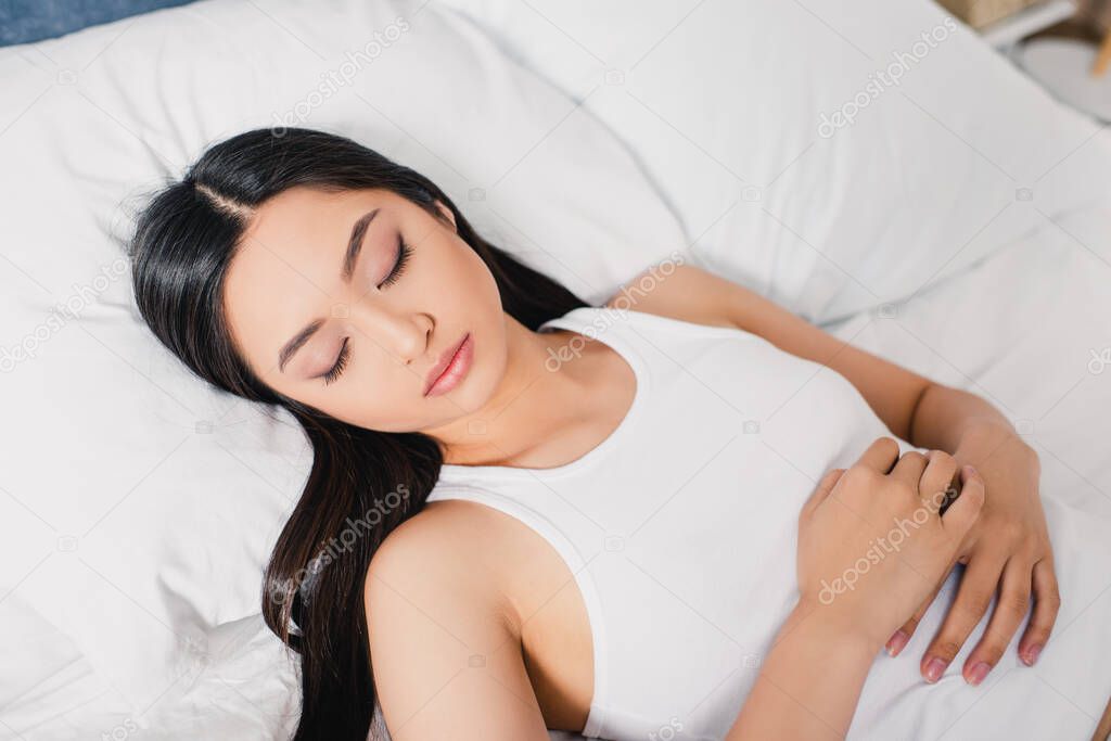 Attractive asian woman sleeping on bed at morning 