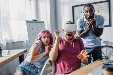 Ofisinde VR kulaklığı olan korkmuş çok ırklı iş adamlarının seçici odağı 