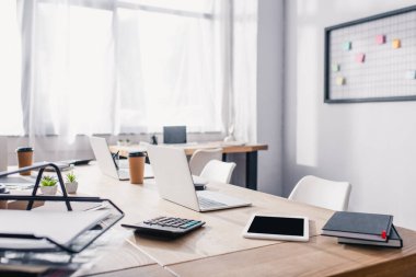 Ofis masasında dijital tabletin, dizüstülerin ve kırtasiyelerin seçici odak noktası 