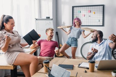 Ofisinde aletleri ve pizza kutuları olan çok kültürlü iş adamlarının seçici odağı. 