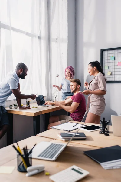 オフィスで共同作業しながら ラップトップを指している多民族ビジネスの人々の選択的な焦点 — ストック写真