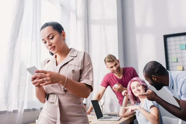 Fokus Selektif Pengusaha Perempuan Menggunakan Smartphone Dekat Kolega Multikultural Dengan — Stok Foto