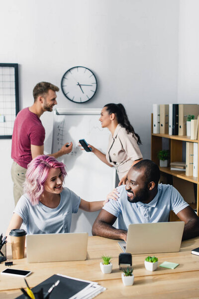 Избирательная направленность мультиэтнических бизнесменов, работающих с гаджетами в офисе 