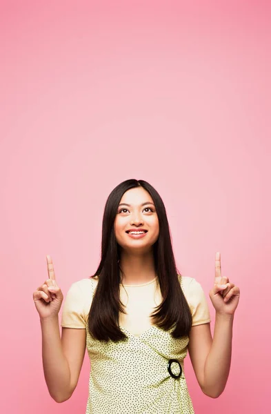 Alegre Asiático Chica Apuntando Con Los Dedos Mirando Arriba Aislado — Foto de Stock