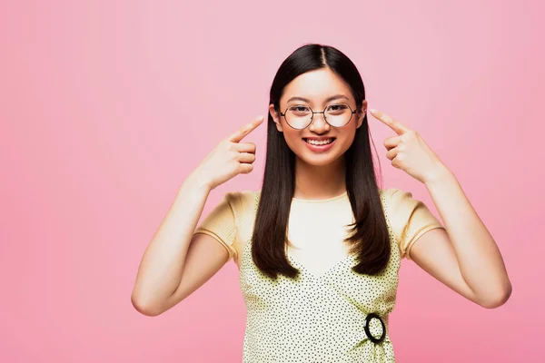 快乐的亚洲女孩用手指指指用粉色隔开的眼镜 — 图库照片