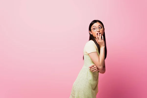 Młoda Azjatka Okularach Zasłaniających Usta Odwracając Wzrok Różowy — Zdjęcie stockowe