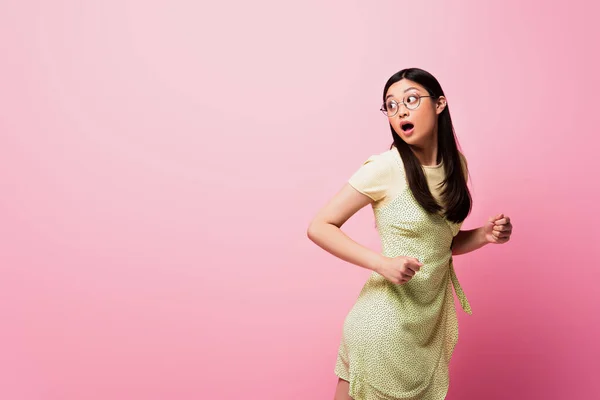 Chockad Asiatisk Kvinna Glasögon Som Springer Och Tittar Bort Rosa — Stockfoto