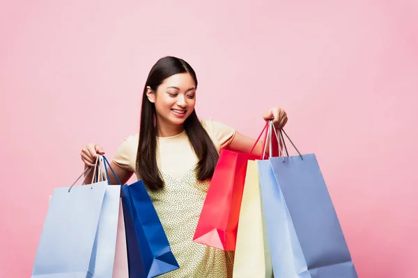 Alegre Joven Asiático Mujer Mirando Compras Bolsas Aislado Rosa —  Fotos de Stock