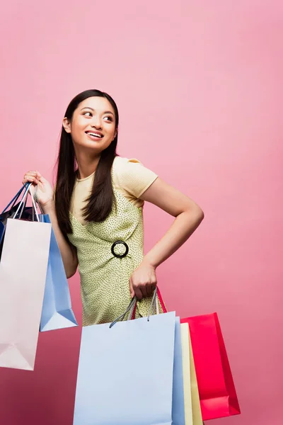 Positive Asian Girl Looking Away While Holding Shopping Bags Pink — Stock Photo, Image