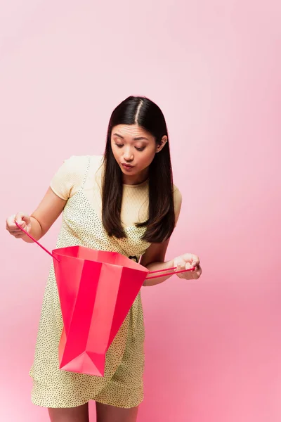 Curious Asian Woman Looking Shopping Bag Isolated Pink — Stock Photo, Image