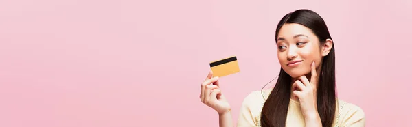 Panoramic Shot Pensive Asian Woman Looking Credit Card Isolated Pink — Stock Photo, Image
