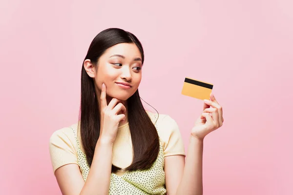 Pensivo Asiático Mulher Olhando Para Cartão Crédito Isolado Rosa — Fotografia de Stock