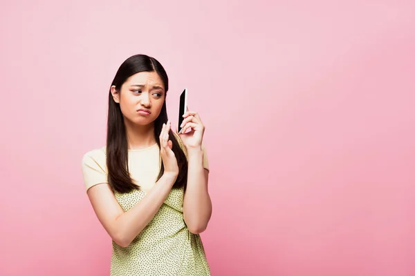 Displeased Asian Woman Gesturing While Holding Smartphone Isolated Pink — Stock Photo, Image