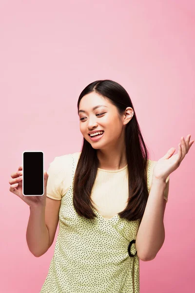 Heyecanlı Asyalı Kadın Pembe Ekranda Boş Ekranlı Akıllı Telefona Bakıyor — Stok fotoğraf
