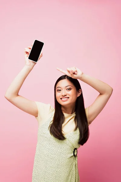 Gadis Asia Ceria Menunjuk Dengan Jari Smartphone Dengan Layar Kosong — Stok Foto