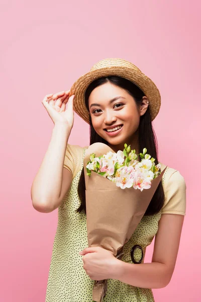 Young Asian Woman Touching Straw Hat Smiling Holding Flowers Isolated — Stock Photo, Image