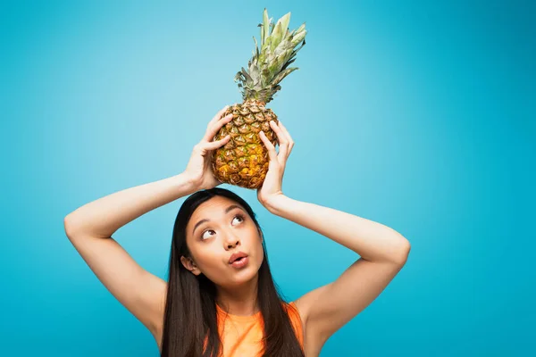 Krásná Asijská Dívka Drží Zralé Ananas Nad Hlavou Modré — Stock fotografie