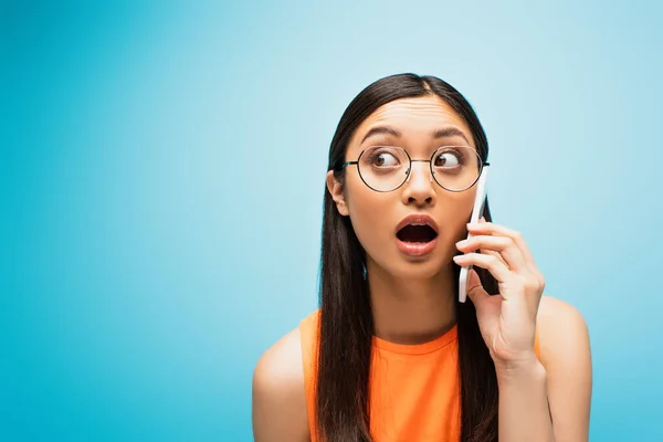 Shocked Asian Girl Glasses Talking Smartphone Blue — Stock Photo, Image