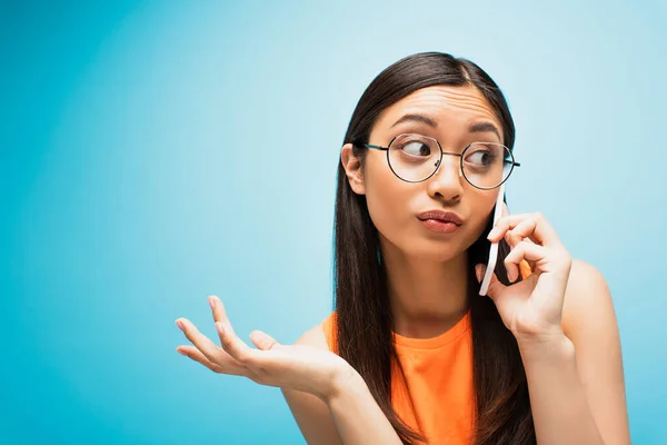 Vonzó Ázsiai Lány Szemüvegben Beszél Okostelefon Gesztikulál Kék — Stock Fotó