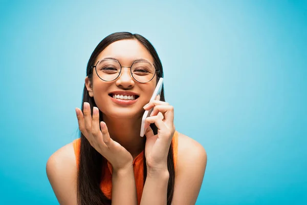 Gözlüklü Neşeli Asyalı Kız Mavi Telefonda Konuşuyor — Stok fotoğraf