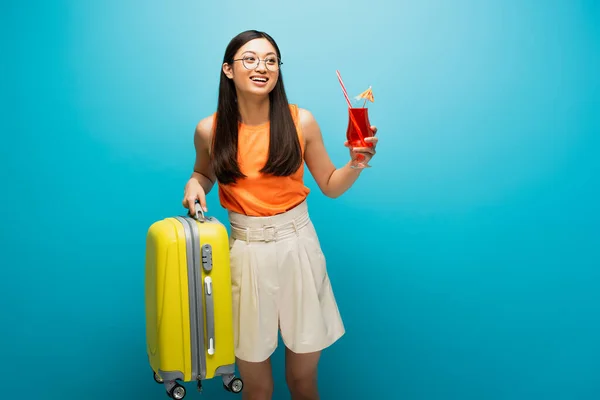 Ευτυχισμένη Ασιάτισσα Γυαλιά Που Κρατάει Κοκτέιλ Και Αποσκευές Στο Μπλε — Φωτογραφία Αρχείου
