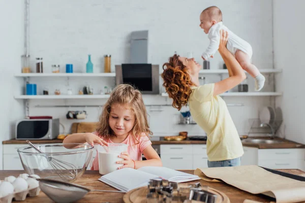 Mädchen Berührt Mehl Maßkrug Der Nähe Von Mutter Die Säugling — Stockfoto