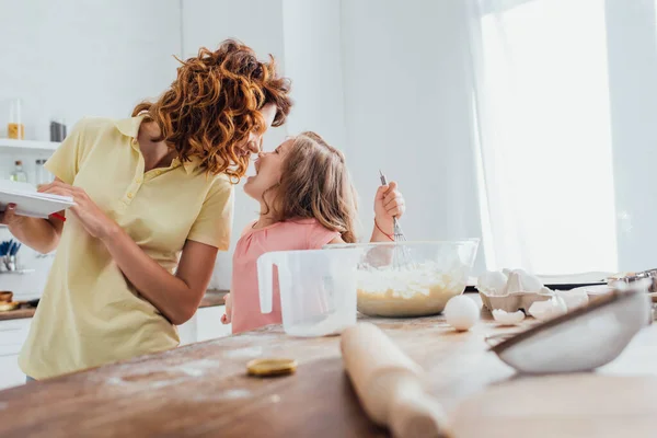 Enfoque Selectivo Madre Sosteniendo Platos Mientras Está Pie Cara Cara — Foto de Stock