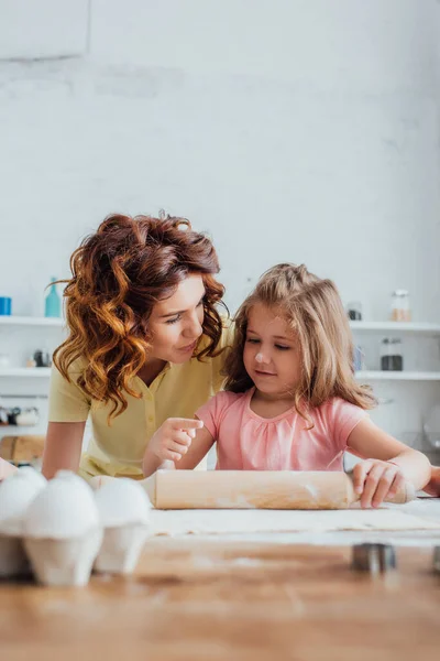 Selective Focus Girl Pointing Finger While Rolling Out Dough Mother — Stock Photo, Image