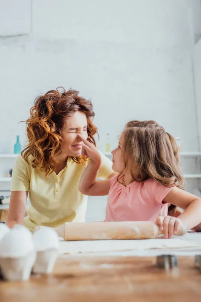 Selective Focus Daughter Touching Nose Mother While Rolling Out Dough — Stock Photo, Image