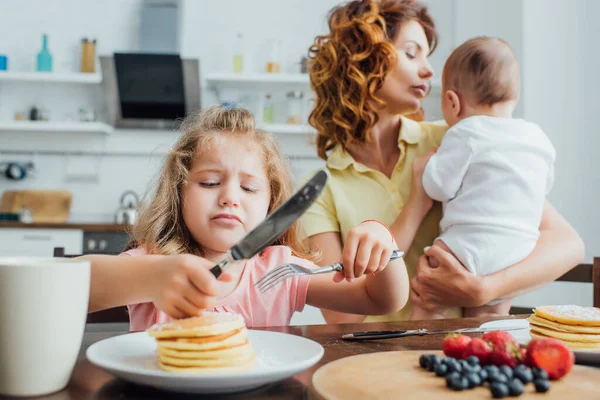 Selektivt Fokus Missnöjd Flicka Håller Gaffel Och Kniv Nära Pannkakor — Stockfoto