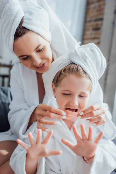 Selectieve Focus Van Vrouw Die Hydrogelpleister Lippen Van Dochter Aanbrengt — Stockfoto