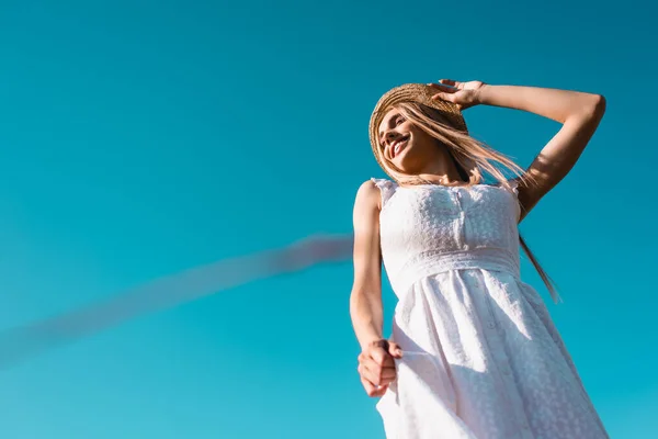 Baixo Ângulo Vista Mulher Loira Vestido Branco Tocando Chapéu Palha — Fotografia de Stock