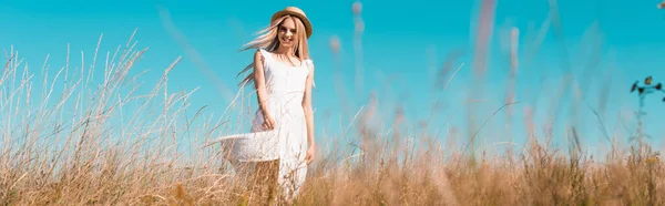 穿着白衣 戴着草帽站在田野风中的金发女子的选择焦点 横向概念 — 图库照片
