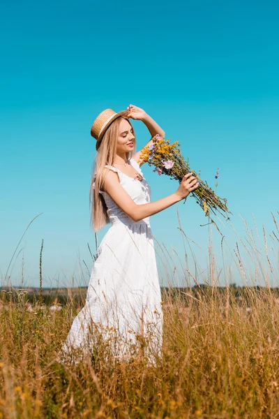 Foco Seletivo Mulher Sensual Vestido Branco Tocando Chapéu Palha Enquanto — Fotografia de Stock