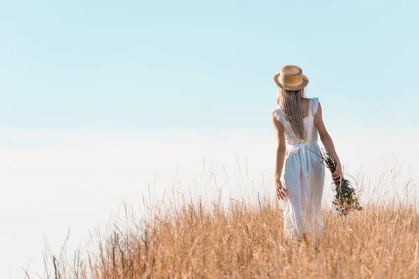 Vista Trasera Mujer Vestido Blanco Sombrero Paja Sosteniendo Flores Silvestres — Foto de Stock