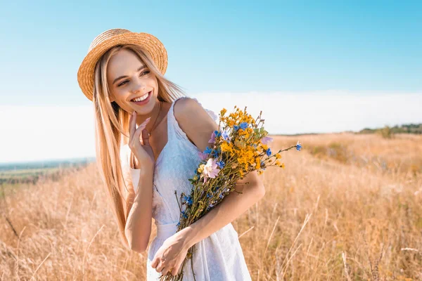Sarışın Şehvetli Hasır Şapkalı Beyaz Elbiseli Elinde Kır Çiçekleri Olan — Stok fotoğraf