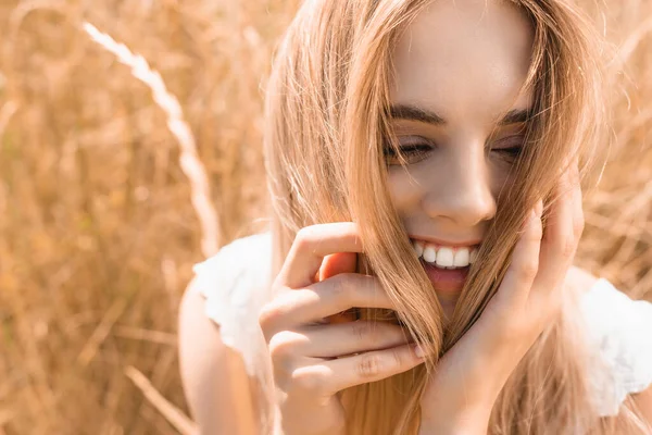 Возбужденная Молодая Блондинка Трогает Волосы Возле Травы Лугу — стоковое фото