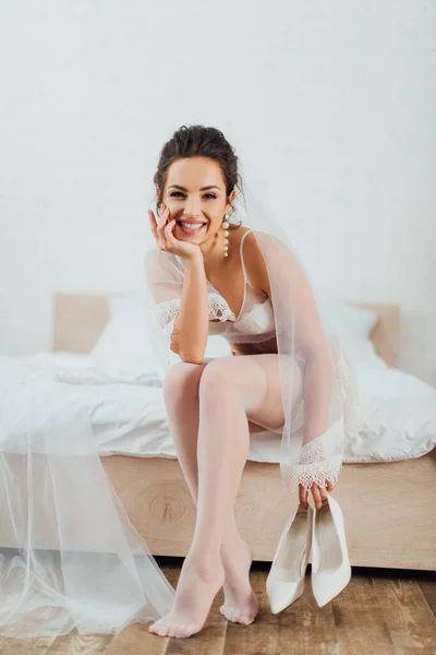 Bride Bra Veil Stockings Looking Camera While Holding Heels Bed — Stock Photo, Image